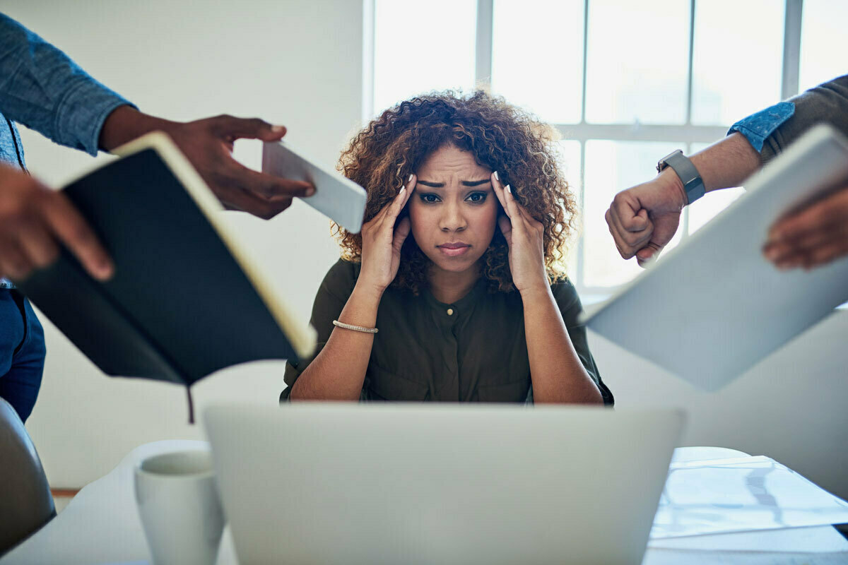 Black woman sitting at a desk appearing stressed